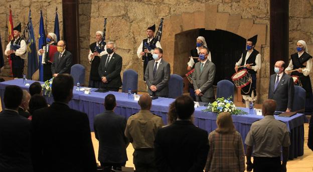 En la mesa, Alfonso López Muñiz, Santiago García Granda, Alfredo Canteli, Pablo Fernández y Alejandro Braña, mientras la Banda de Gaitas interpreta el himno de Asturias. 