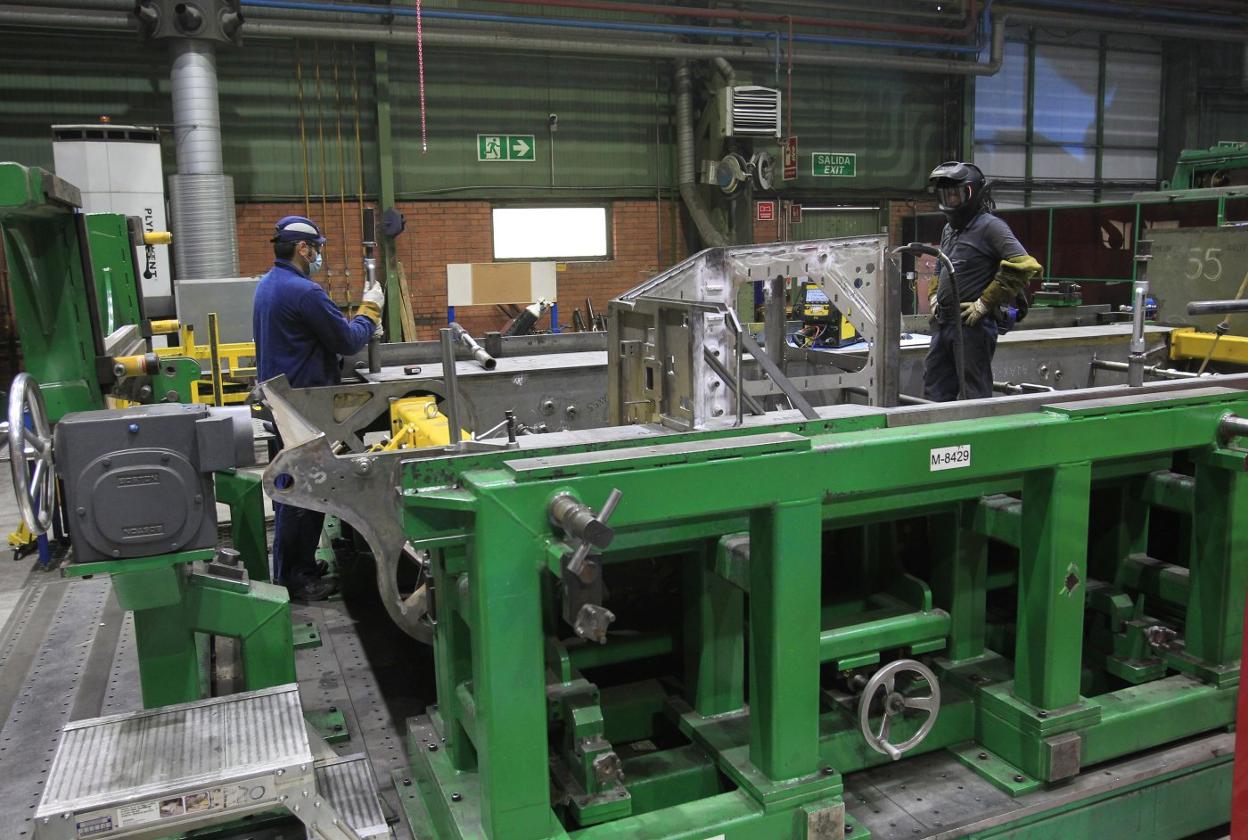 Dos trabajadores de Santa Bárbara, en la fábrica de armas de Trubia, en medio de la producción de los vehículos Ajax y Castor. 