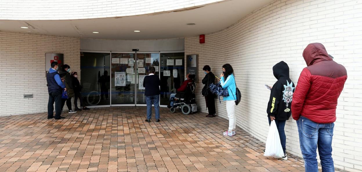 Pacientes en la entrada del centro de salud de La Corredoria. 