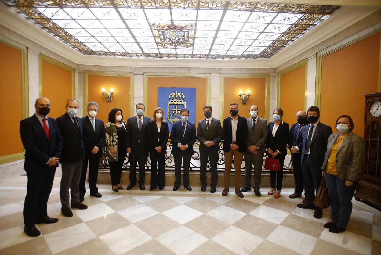 El alcalde, Alfredo Canteli, y el consejero de Industria, Enrique Fernández, en el centro de la imagen y flanquedos por el concejal de Economía, Javier Cuesta, y la directora del Idepa, Eva Pando, además de representantes de las entidades financieras que colaboran con Asturgar. 