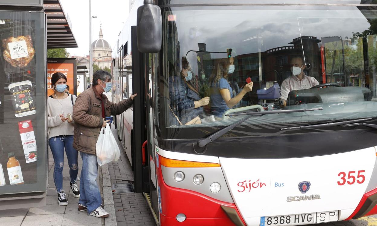 Varios ciudadanos se suben a un autobús en la parada de la Gota de Leche. 