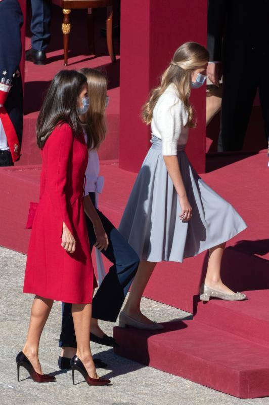 El estilismo de la Reina Letizia, de la Princesa Leonor y de la Infanta Sofía durante el desfile del 12 de octubre en la plaza de la Armería del Palacio Real de Madrid han captado la atención mediática. La Reina ha vuelto a apostar por Felipe Varela y ha rescatado un sobrio dos piezas de inspiración oriental, formado por un vestido de terciopelo con botones y un abrigo recto en crepe que se abrocha con pequeños lazos. La Princesa Leonor ha lucido una falda abullonada de color azul y un cuerpo con mangas de farol, del que prendía la insignia de la orden del Toisón de Oro. La Infanta Sofía, mucho más sobria, ha optado este 12-O por un conjunto compuesto por un pantalón ancho y una camisola con gran lazada.