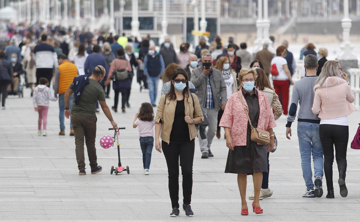 Personas de paseo por El Muro de Gijón 