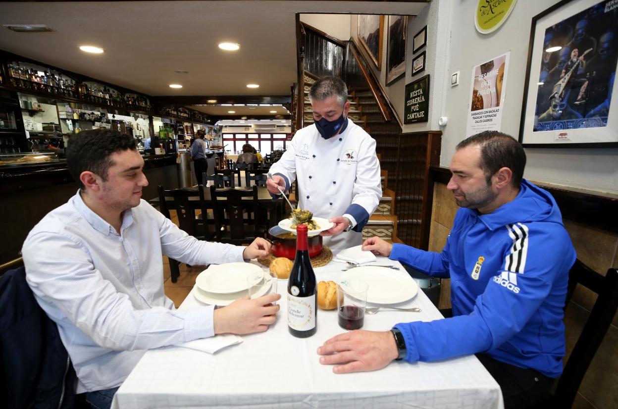 El dueño del Pigüeña, Marco Rodríguez, sirve el menú del Desarme a Álvaro y Francisco Fernández. 