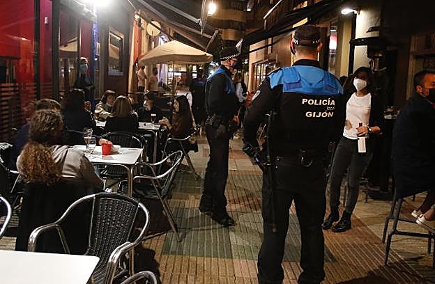 Agentes de la Policía Local de Gijón revisan el cumplimiento de las medidas en El Carmen. 
