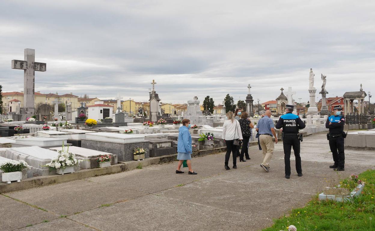 Agentes de la Policía Local informando de las restricciones a los pocos visitantes que se acercaron al Cementerio Municipal de La Carriona esta mañana. 