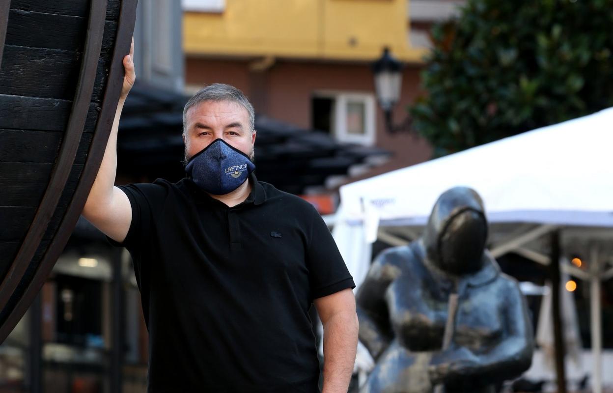 El presidente de la Asociación de Hosteleros de Gascona, el Bulevar de la Sidra, Pedro Caramés, posa para EL COMERCIO frente al tonel de la entrada a la calle. 