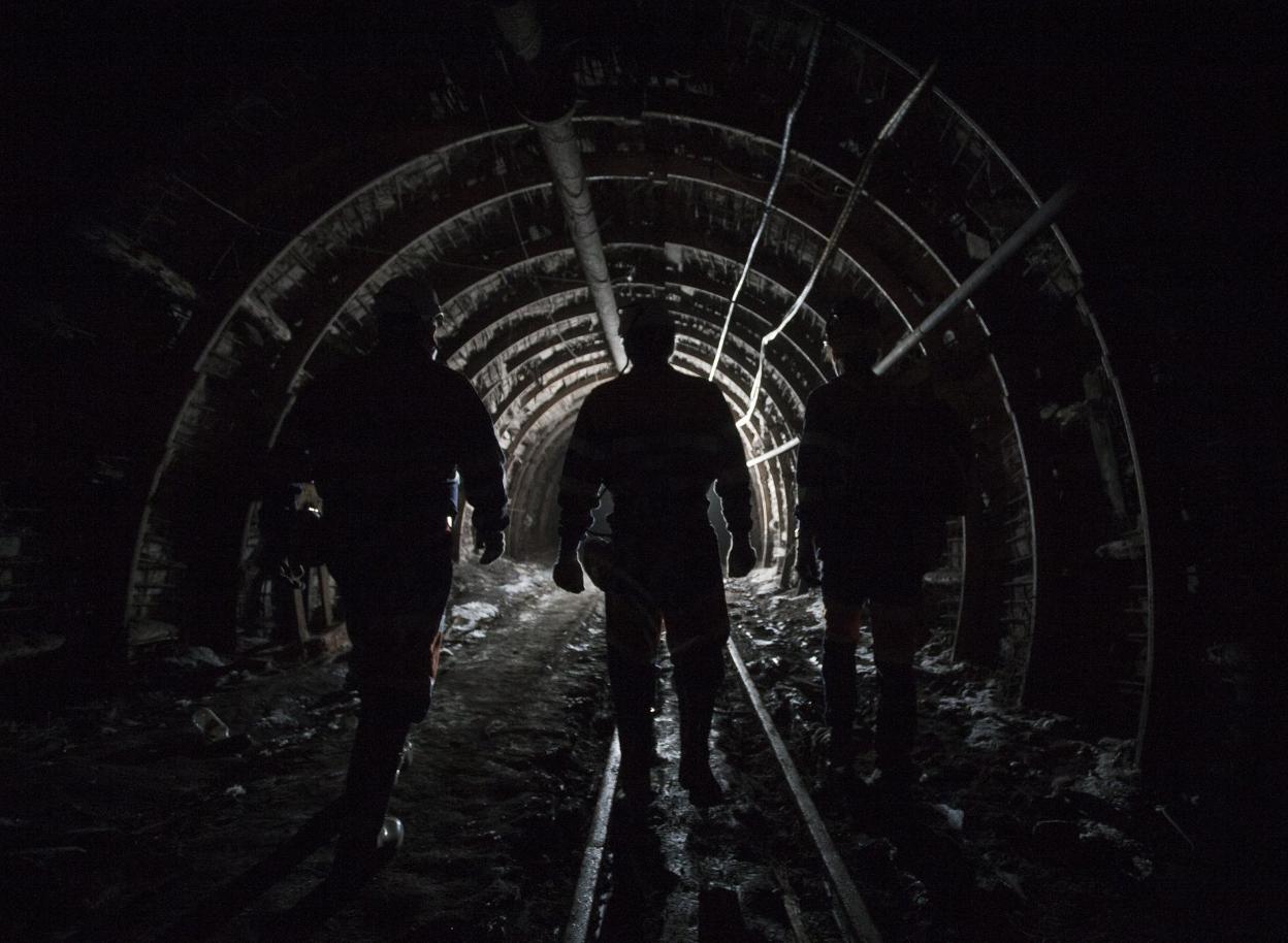 Tres mineros en el interior de una mina. 