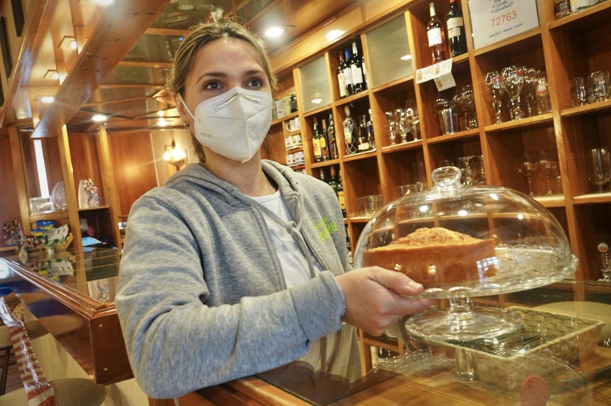 Arriba, Elena Botan con uno de los bizcochos caseros que sirve en El Camperu, en Arriondas. Abajo, Triana Martín coloca una de sus creaciones en su tienda TMV de Cangas de Onís. 