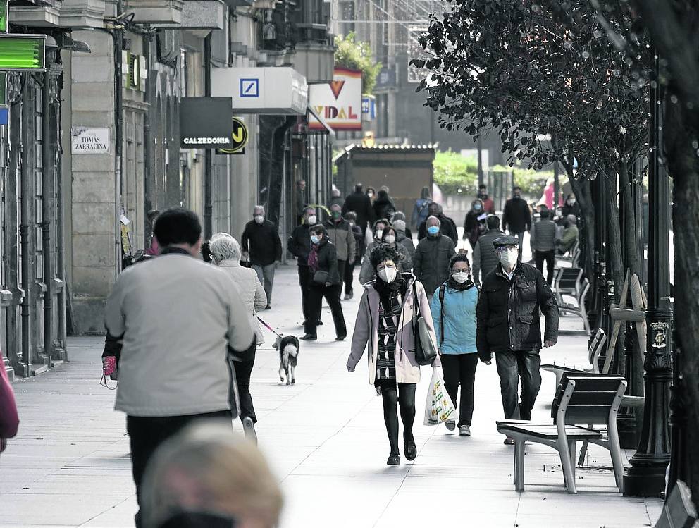 Paseantes en la calle Corrida de Gijón, al mediodía.