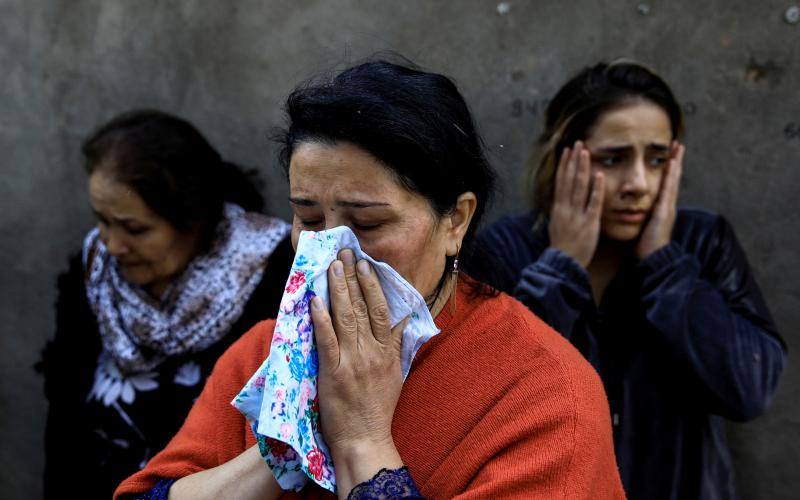 Tres mujeres, desconsoladas al no encontrar a sus familiares, que permanecen atrapados bajo los escombros tras la explosión provocada por un cohete durante los combates en la región separatista de Nagorno-Karabaj, en la ciudad de Ganja, Azerbaiyán, el 11 de octubre de 2020. 