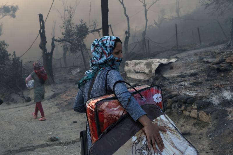 Una mujer lleva sus pertenencias, tras el incendio en el campamento de refugiados de Moria, en la isla de Lesbos, Grecia, el 9 de septiembre de 2020. 