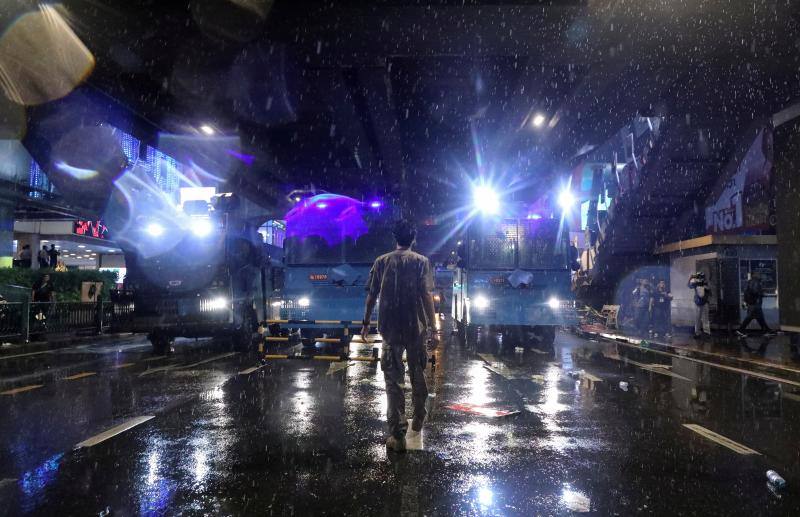 Un hombre camina bajo la lluvia en la carretera durante las protestas contra el gobierno en Bangkok, Tailandia, el 16 de octubre de 2020. 