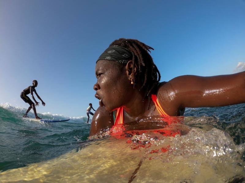 Khadjou Sambe, de 25 años, la primera surfista profesional de Senegal, practica surf durante una sesión de entrenamiento frente a la costa de Ngor, Dakar, Senegal, el 18 de agosto de 2020. "Cuando estoy en el agua siento algo extraordinario, algo especial en mi corazón", confesó Sambe. 