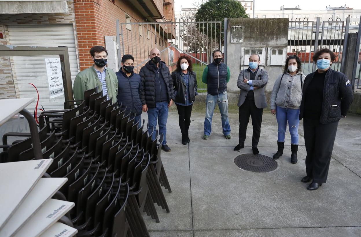 Comerciantes y hosteleros del barrio de Laviada, en la calle Juanín de Mieres, junto a una terraza recogida. 