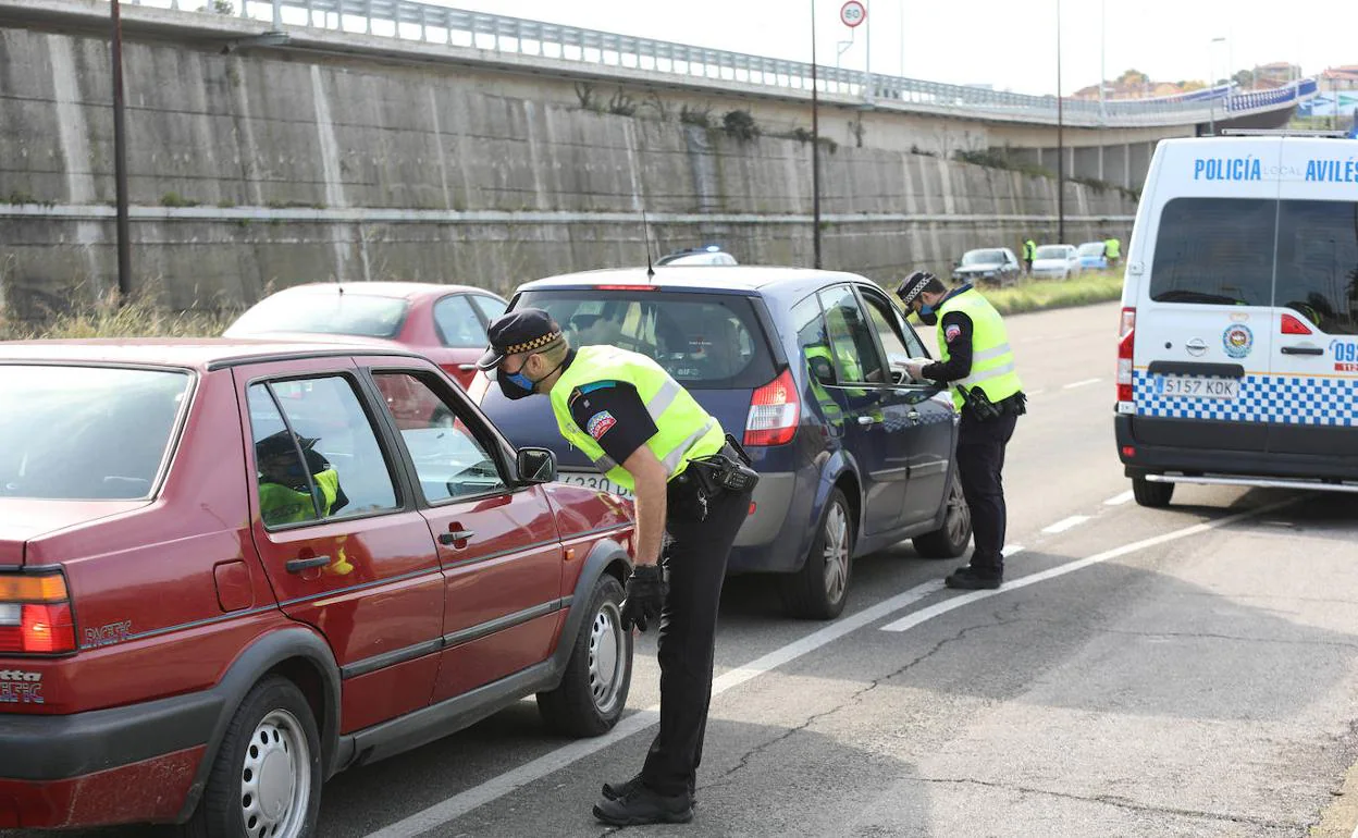 Dos agentes de la Policía Local de Avilés realizan un control rutinario a vehículos. 