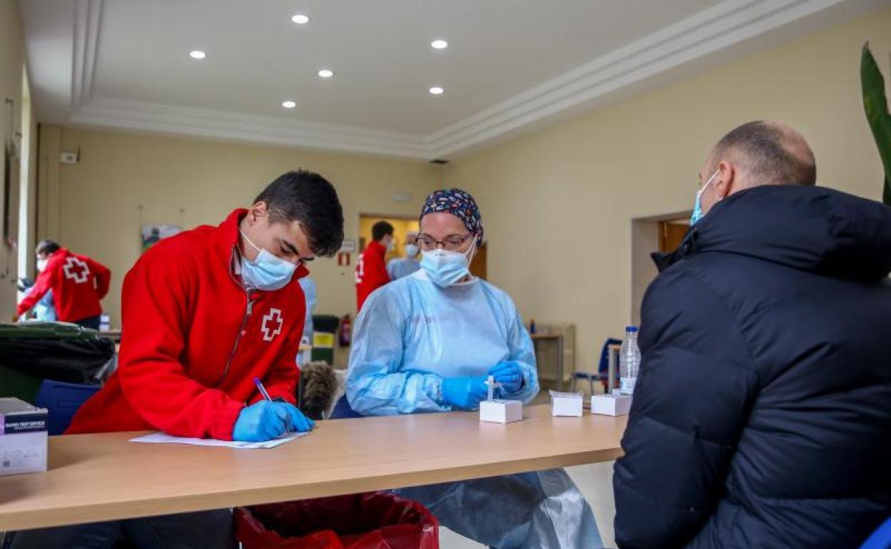 Un trabajador de Cruz Roja, una sanitaria y un hombre en un dispositivo para la realización de test de antígenos organizado por la Comunidad de Madrid 