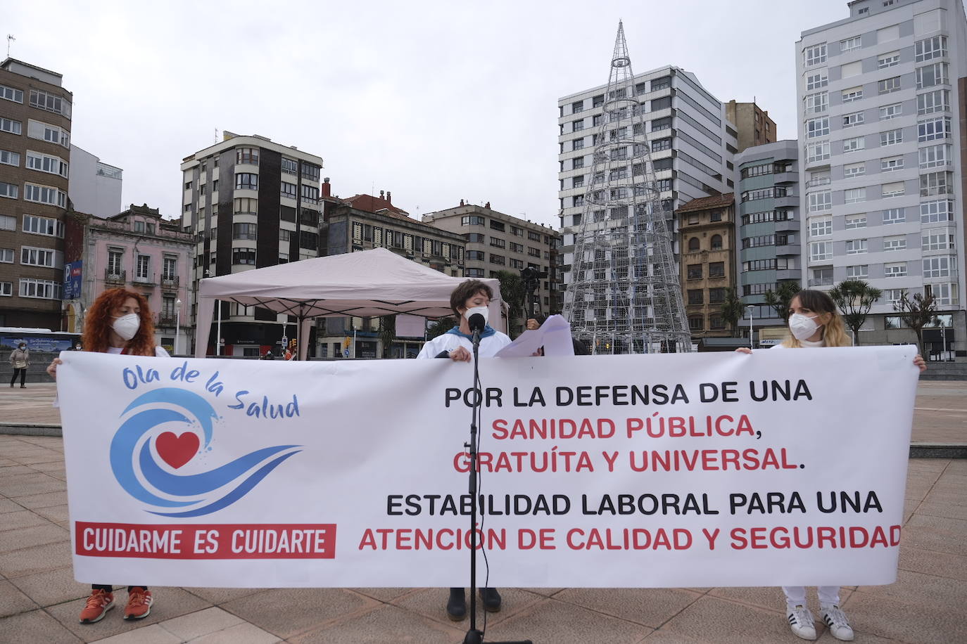Decenas de personas se han sumado a una cadena humana en el muro de San Lorenzo, en Gijón. Se trata de una iniciativa en defensa de la sanidad pública.