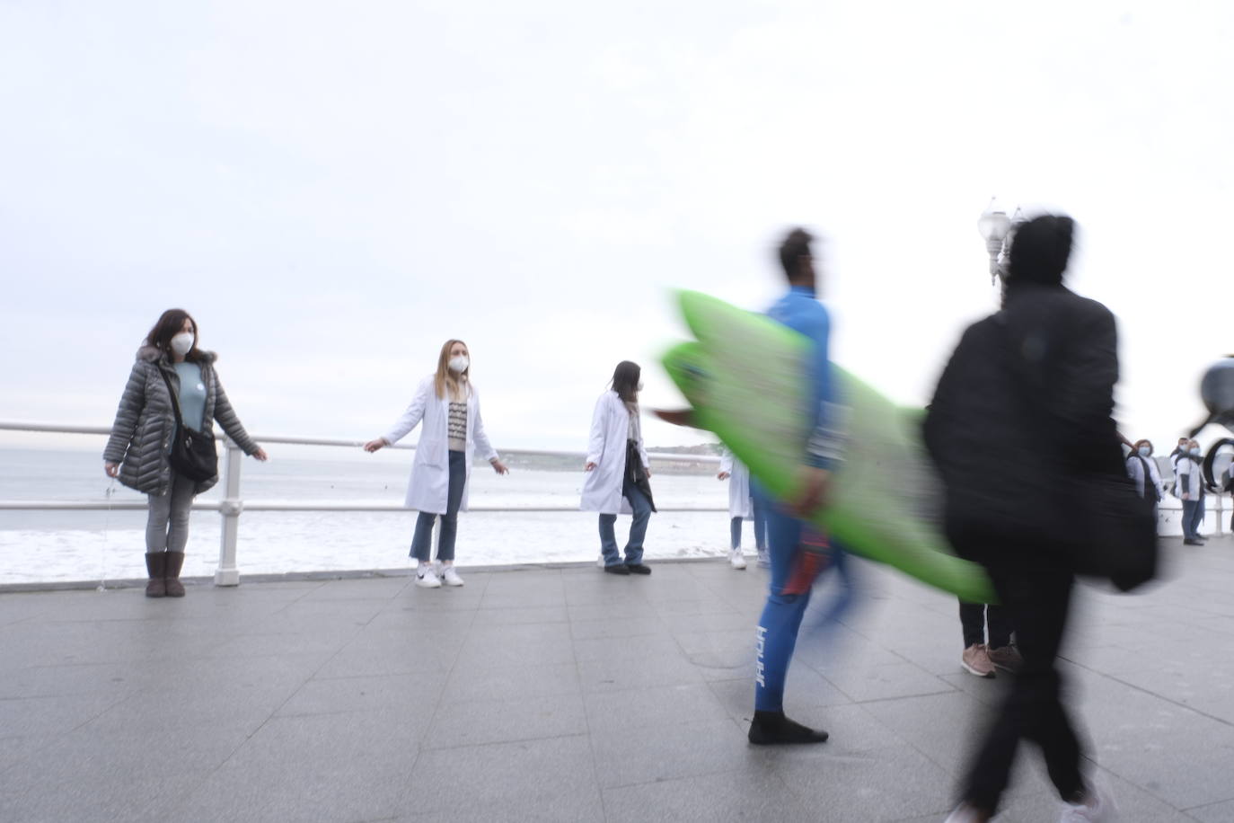Decenas de personas se han sumado a una cadena humana en el muro de San Lorenzo, en Gijón. Se trata de una iniciativa en defensa de la sanidad pública.
