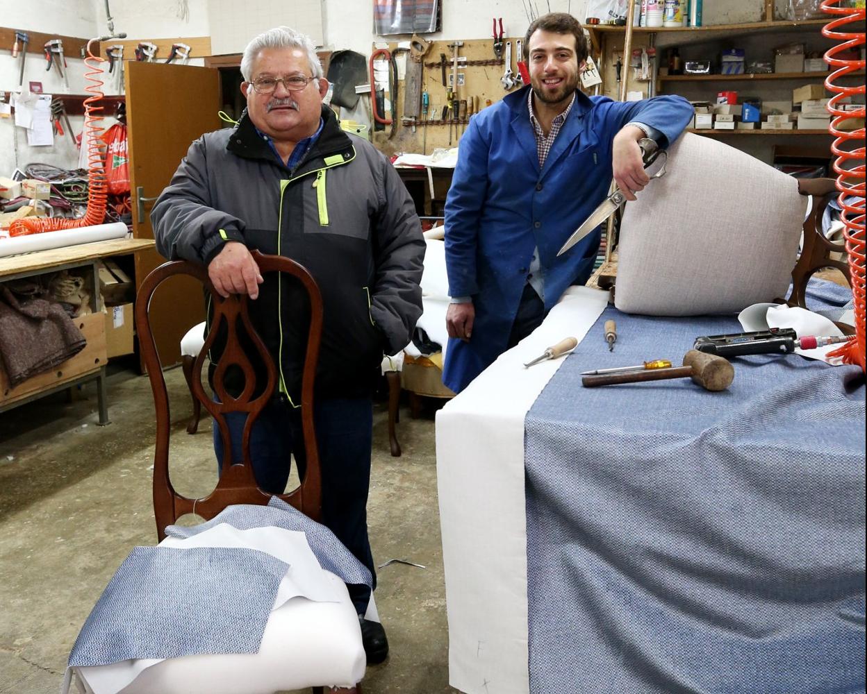 Lucinio y Sergio Rodríguez, en su taller junto a unas sillas y una chenilla aterciopelada. 