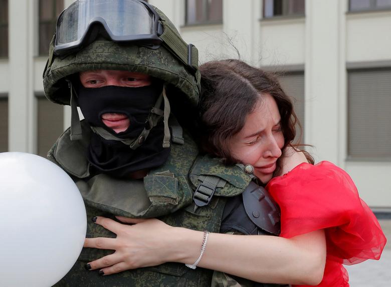 Bielorrusia | Un participante abraza a un miembro de las tropas del Ministerio del Interior de Bielorrusia que hace guardia durante una manifestación de la oposición para protestar contra la violencia policial y rechazar los resultados de las elecciones presidenciales cerca de la Casa de Gobierno en la Plaza de la Independencia en Minsk.