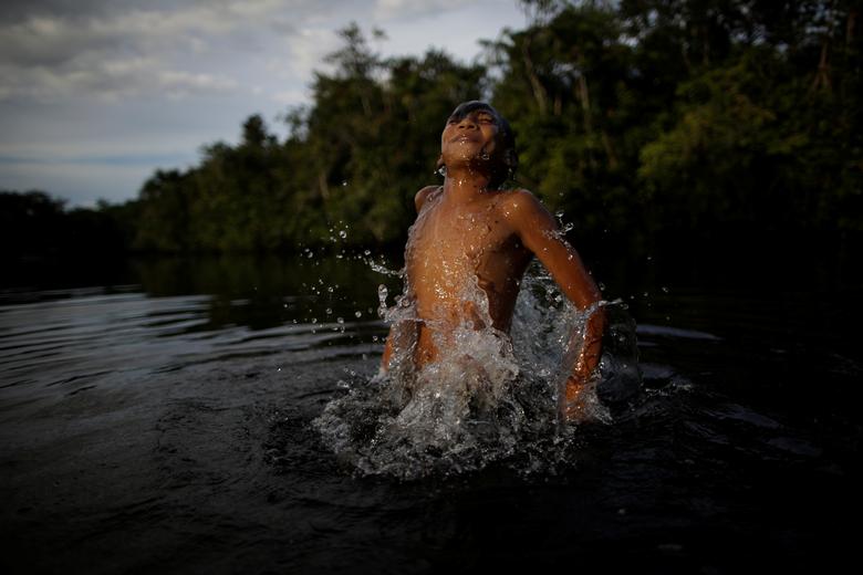 Brasil | Luciendro Costa, de 13 años, cuya madre dio positivo por covid-19, se baña en el río Acuti Pereira en la comunidad ribereña de Menino de Deus, mientras trabajadores de la salud visitan comunidades ribereñas para controlar a los residentes durante el brote de coronavirus, en el municipio de Portel, en la isla de Marajo, estado de Pará, Brasil.