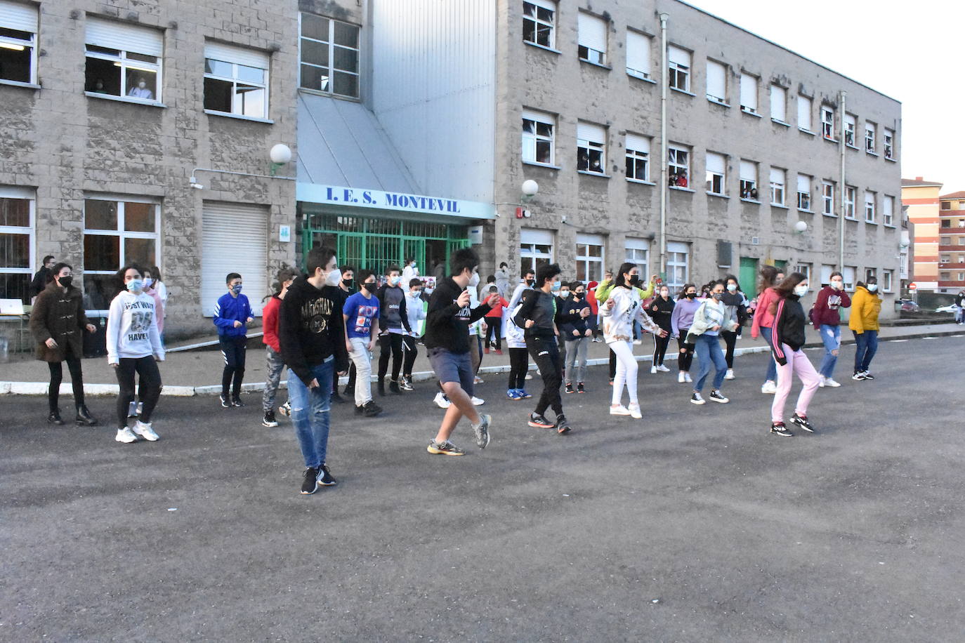 Son sus vecinos. Frente a frente instituto y residencia. Tan juntos pero a tanta distancia. Y en una situación tan especial y tan dura como esta pandemia. Por eso los estudiantes del IES Montevil de Gijón decidieron salir este miércoles delante del instituto para transmitirles ánimos y desearles unas felices fiestas a los mayores que cada día les ven entrar y salir con sus mochilas. Con bailes, con pancartas y con saludos les hicieron ver que no están solos y que los abuelos son muy especiales.