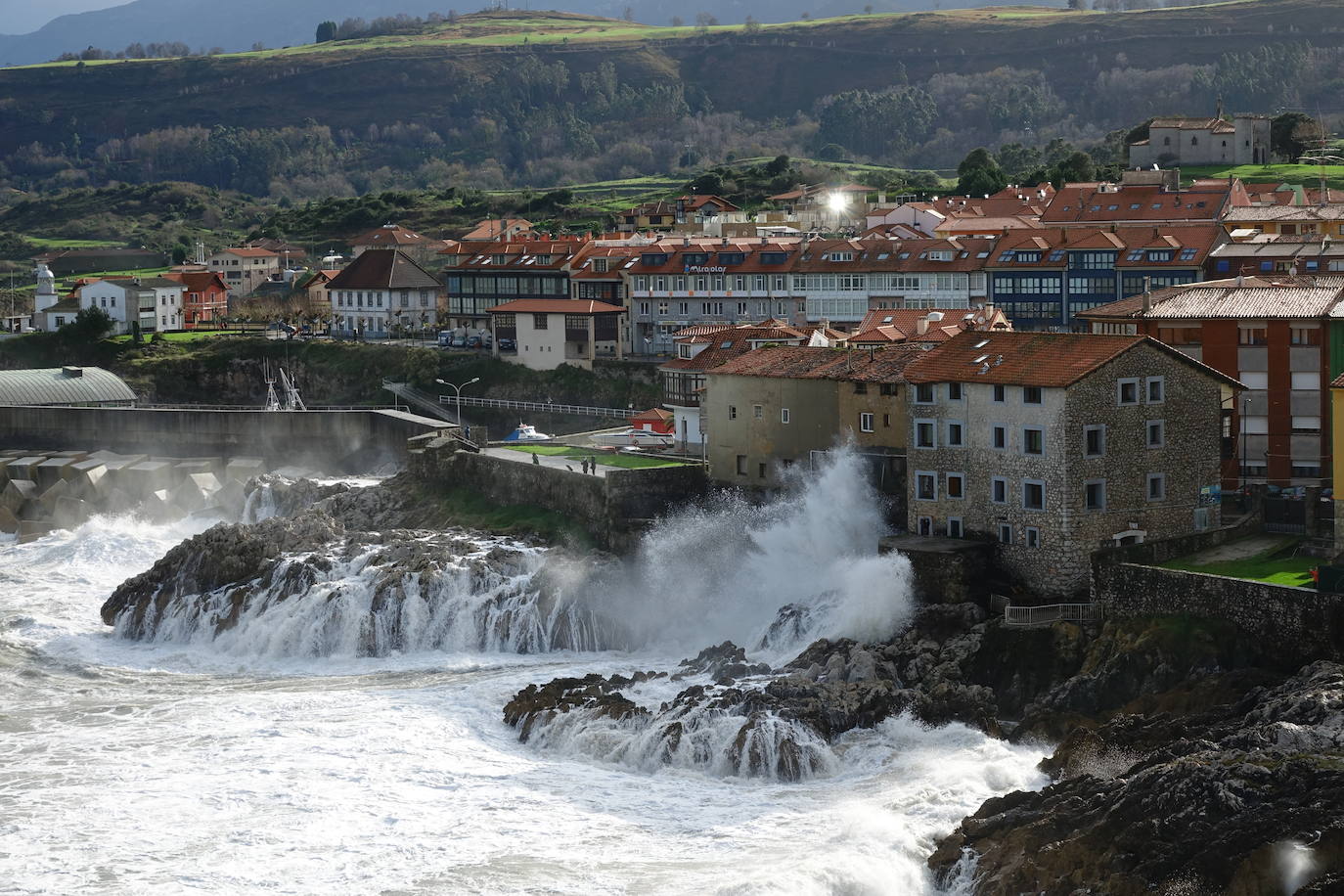 La borrasca 'Bella' ha provocado más de 1.900 incidencias en Asturias y complica las comunicaciones. La nieve acumulada en las últimas horas, que ha cerrado el puerto del Connio, obliga a usar cadenas en 15 altos de montaña. Los fuertes vientos han procovado la caída de árboles y la Aemet mantiene el litoral del Principado en alerta roja por olas de hasta diez metros 