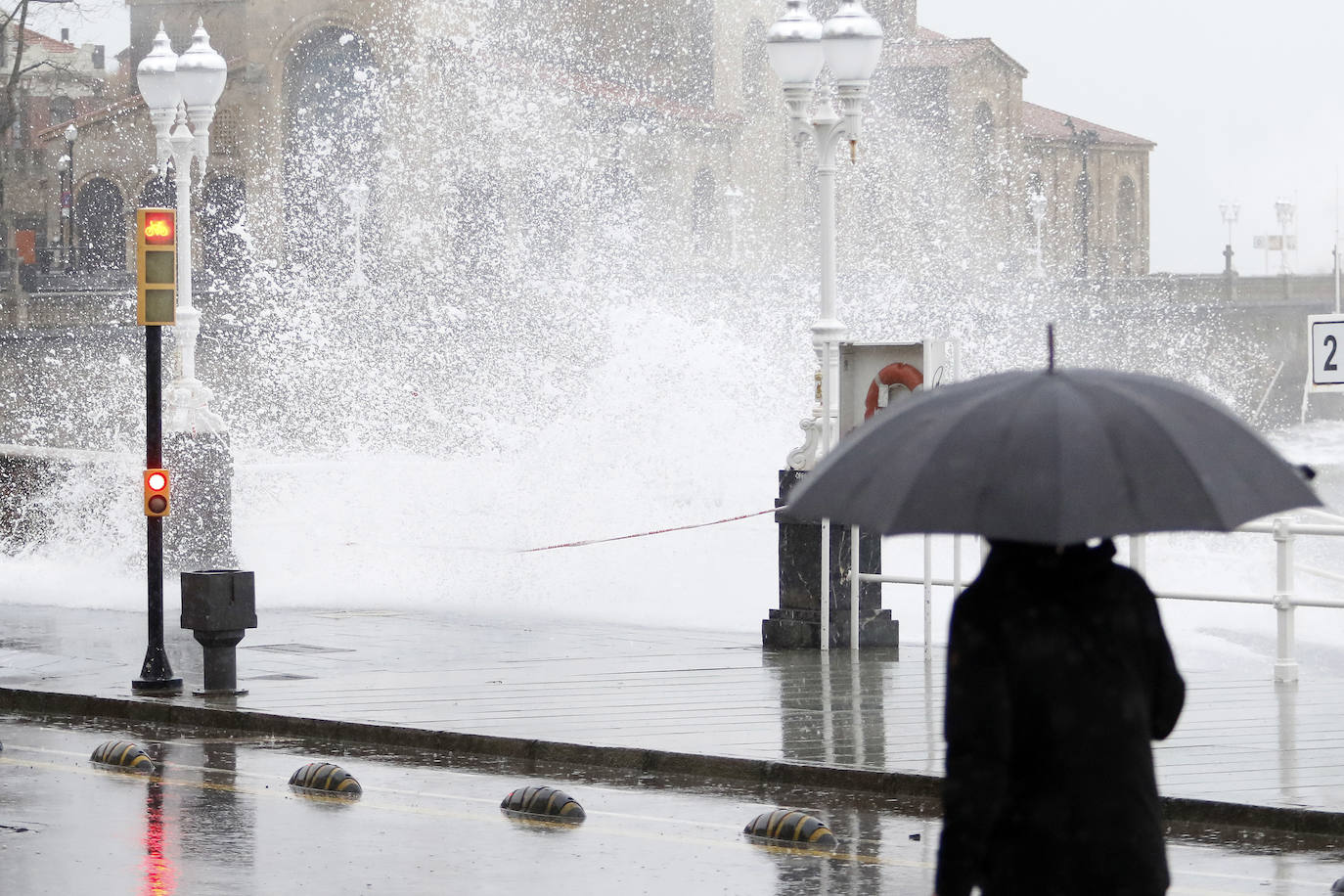 La borrasca 'Bella' ha provocado más de 1.900 incidencias en Asturias y complica las comunicaciones. La nieve acumulada en las últimas horas, que ha cerrado el puerto del Connio, obliga a usar cadenas en 15 altos de montaña. Los fuertes vientos han procovado la caída de árboles y la Aemet mantiene el litoral del Principado en alerta roja por olas de hasta diez metros 