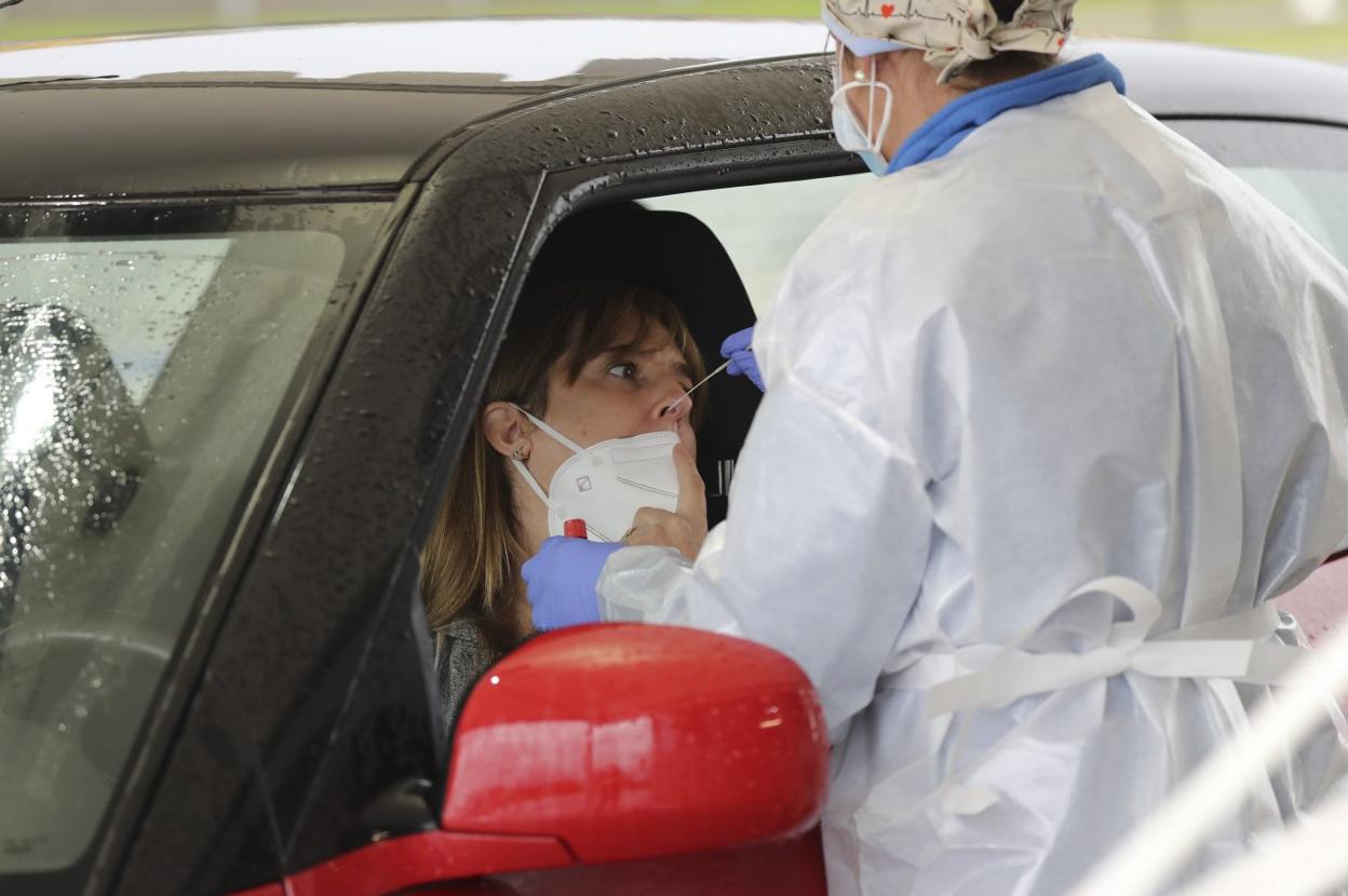 Una enfermera realiza una prueba PCR a una mujer en el autocovid de Marina Civil, en Gijón. 