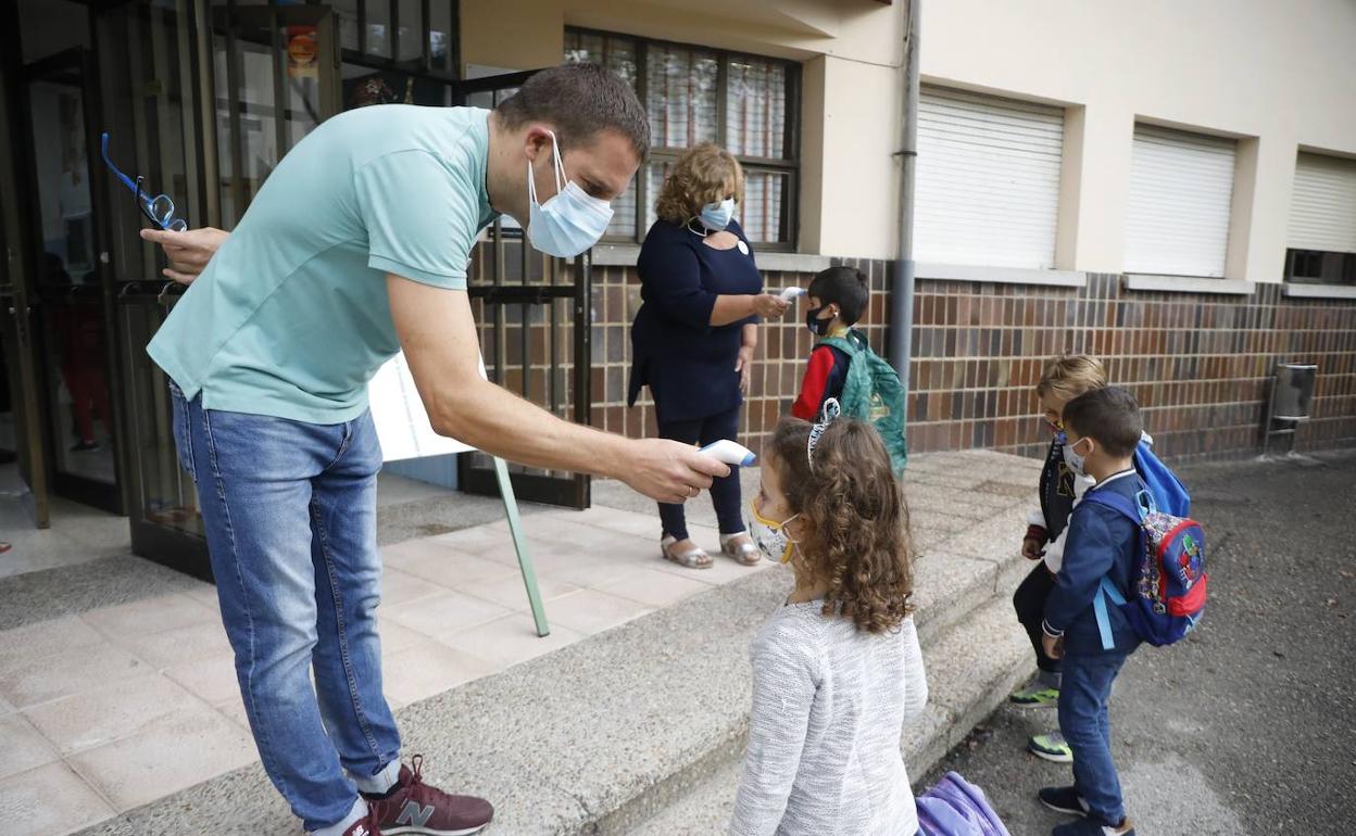 Toma de temperatura a un escolar en el colegio de Lada.