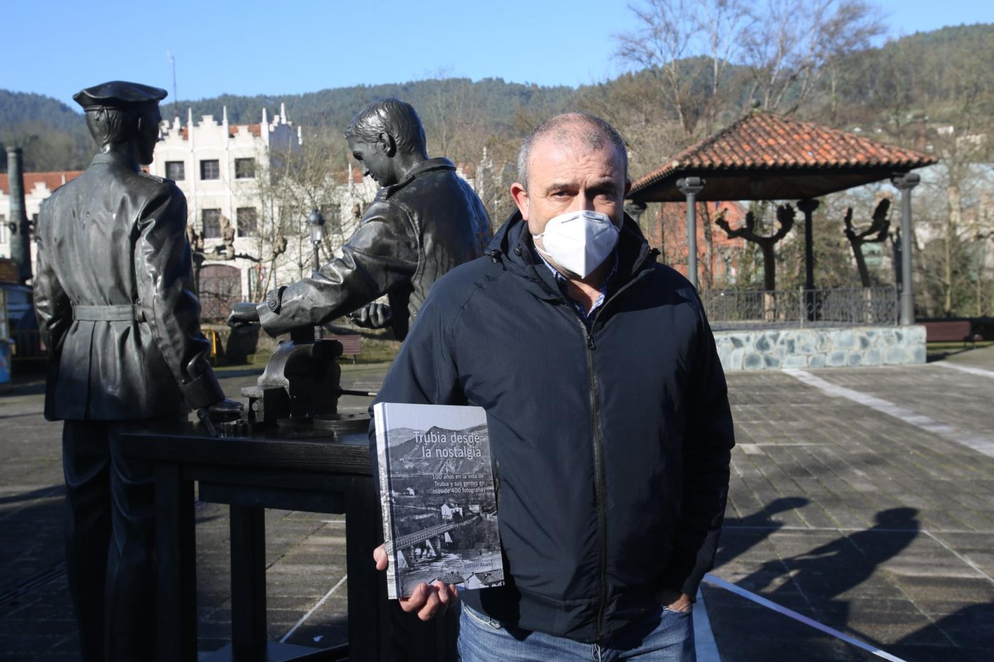 Nostalgia. Valentín Álvarez, editor del libro, posa en la plaza de Trubia, con la fábrica de armas al fondo. 