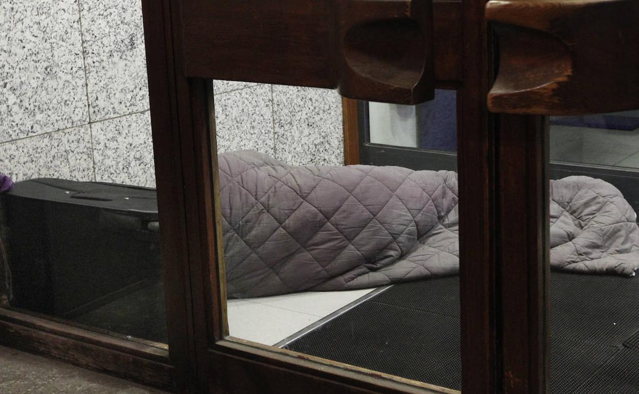 Una persona durmiento en la calle en invierno. 