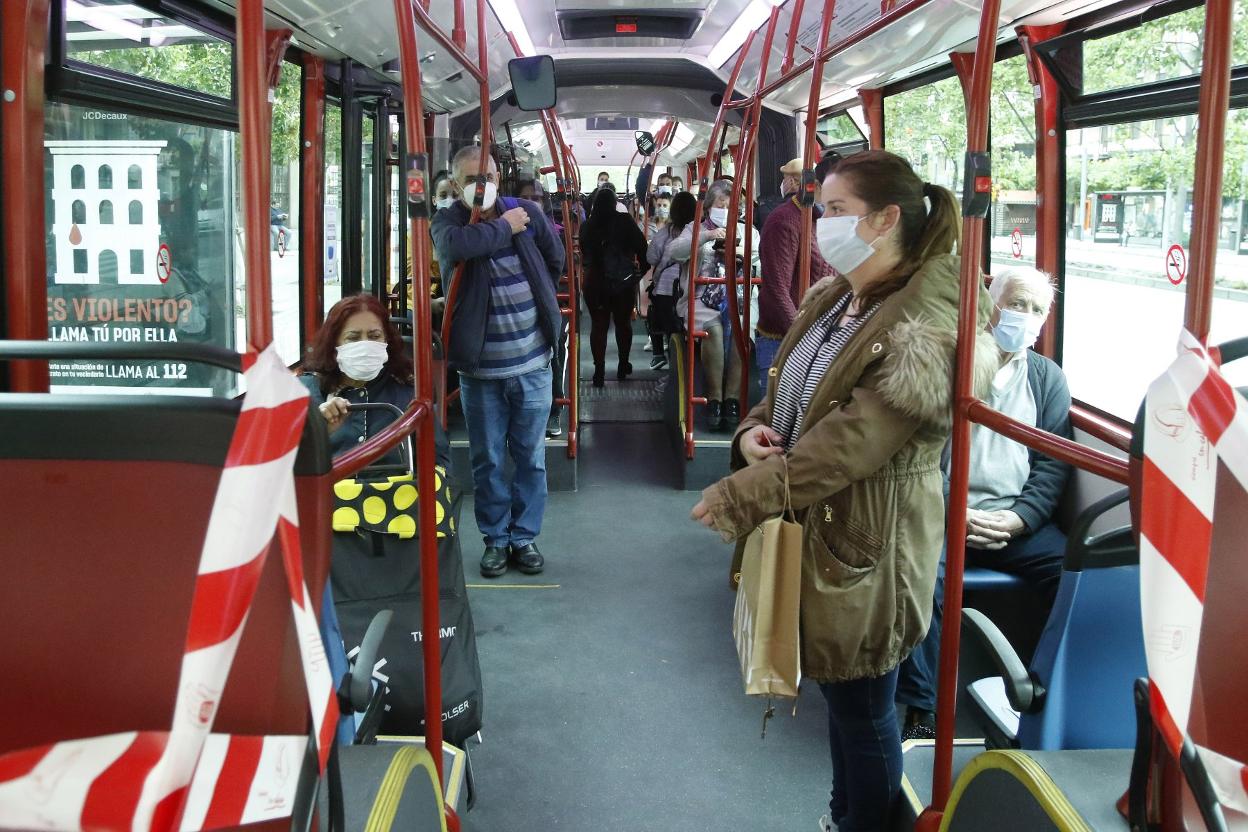 Viajeros, con la mascarilla puesta, en un autobús de EMTUSA. 
