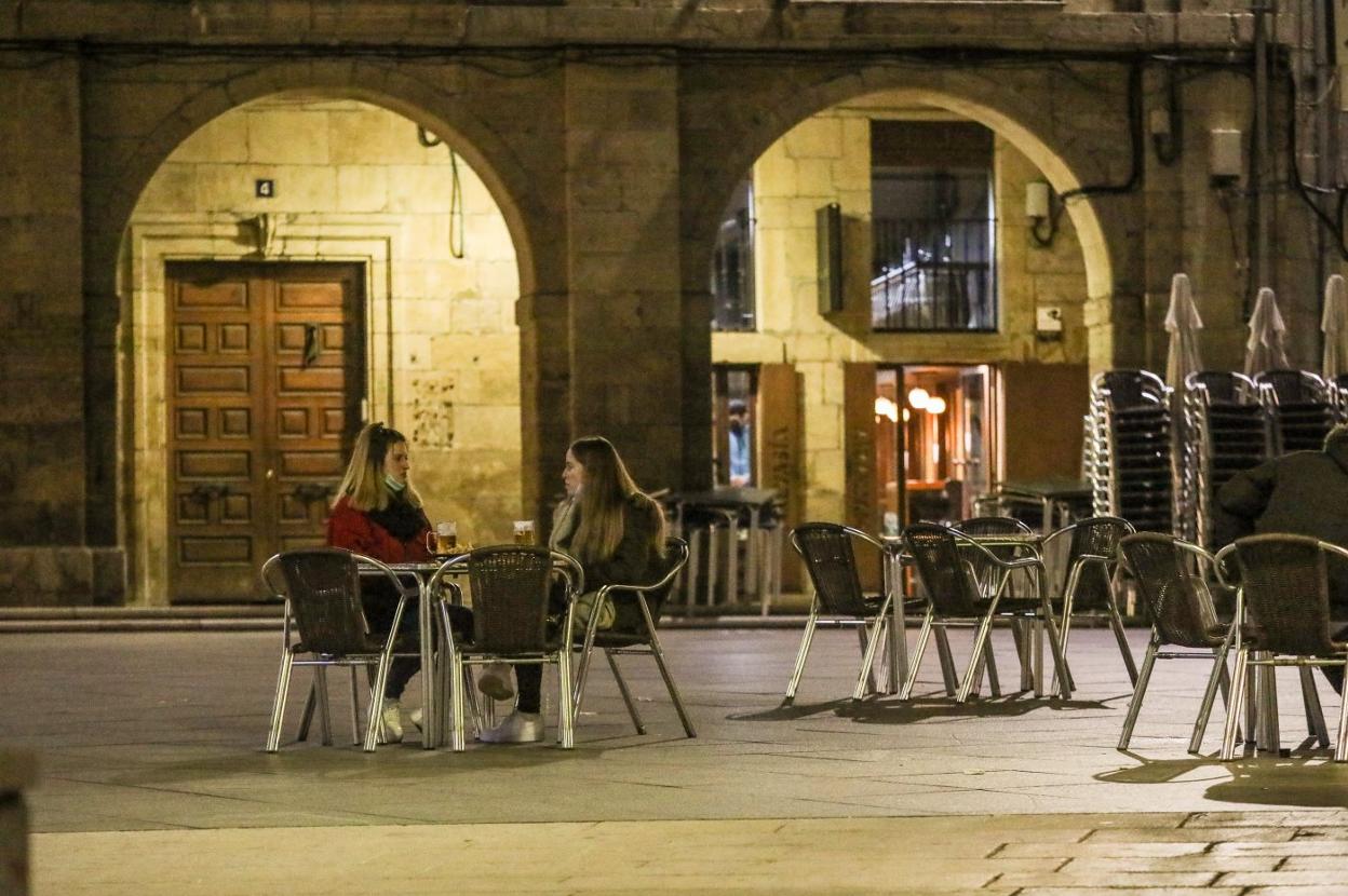 Dos jóvenes en una terraza de la plaza de España. 