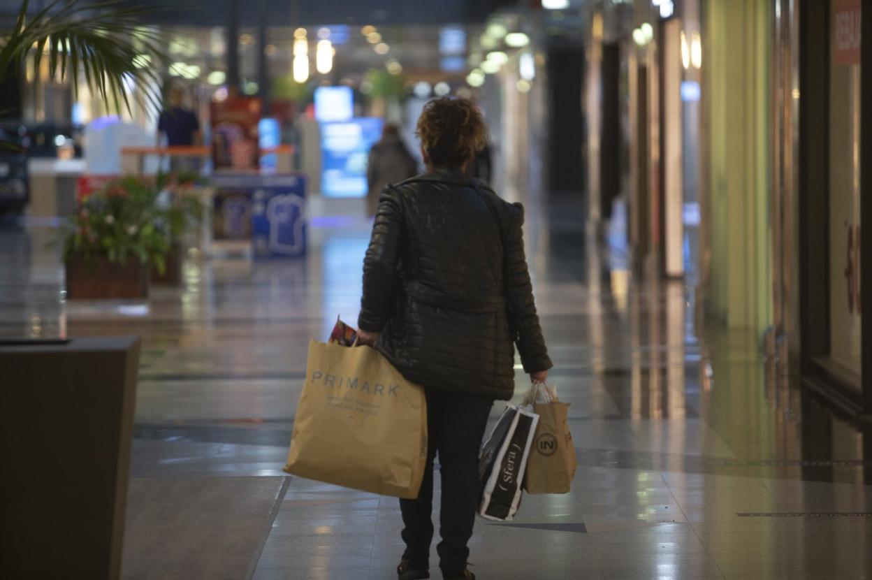 Una clienta cargando bolsas, tras sus compras a primera hora en Parque Principado. 