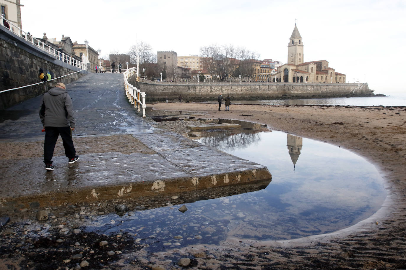 El arenal gijonés de San Lorenzo ha aparecido este martes cubierto por una capa de ocle. 