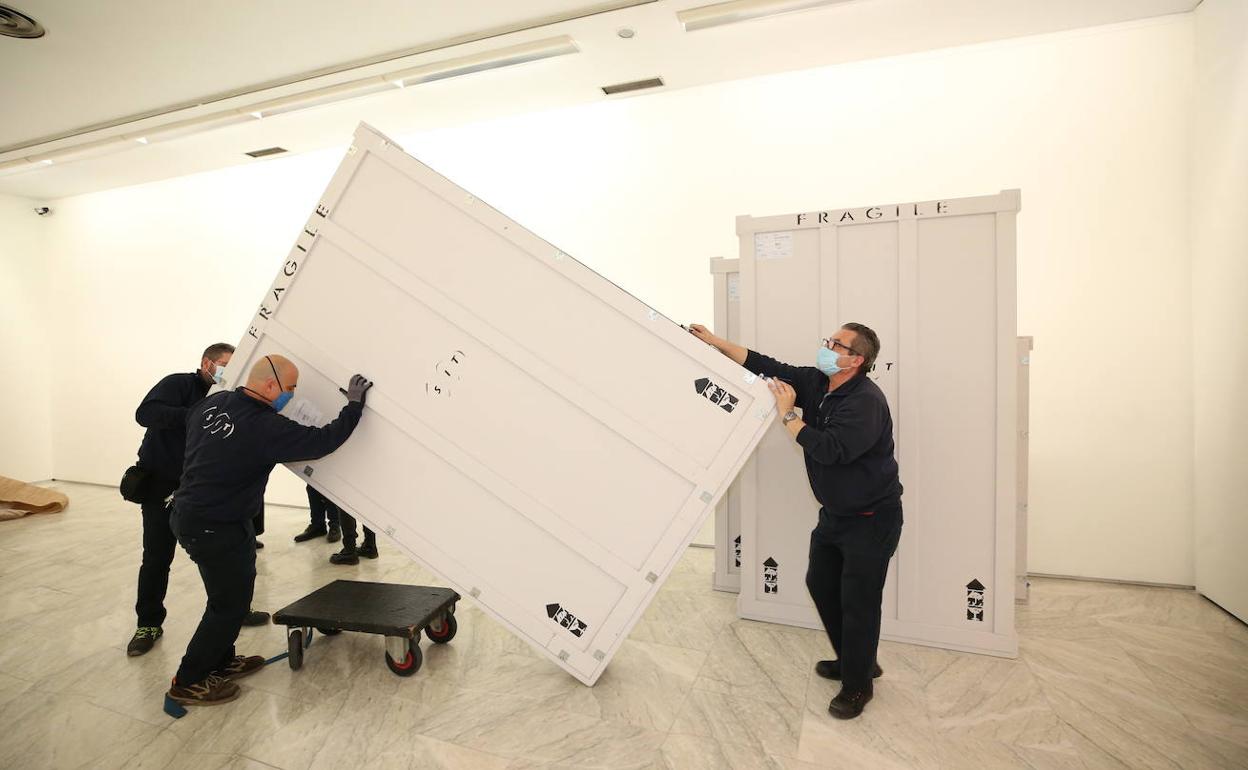 Varios operarios colocan las obras en una sala del museo donde permanecerán 24 horas.