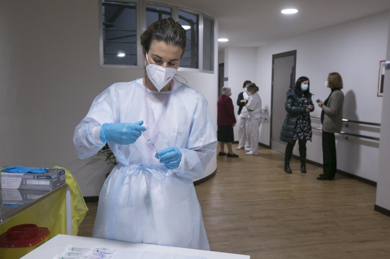 Una enfermera prepara una vacuna para inocular a usuarios de la Residencia Mixta de Pumarín. 