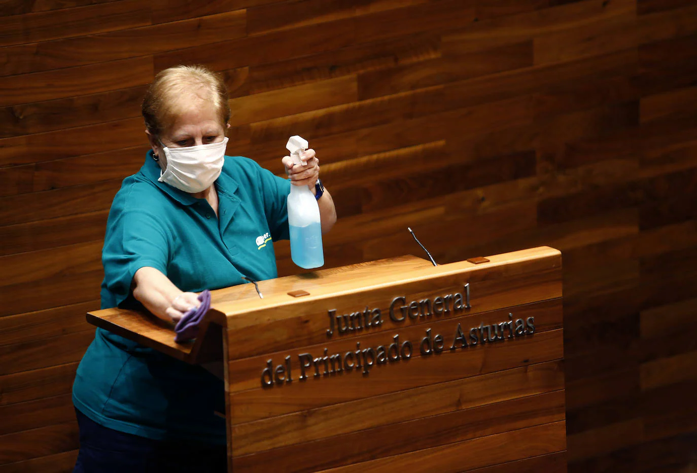 Una trabajadora limpia la tribuna de la Junta General del Principado de Asturias durante el debate sobre el estado de la región. 