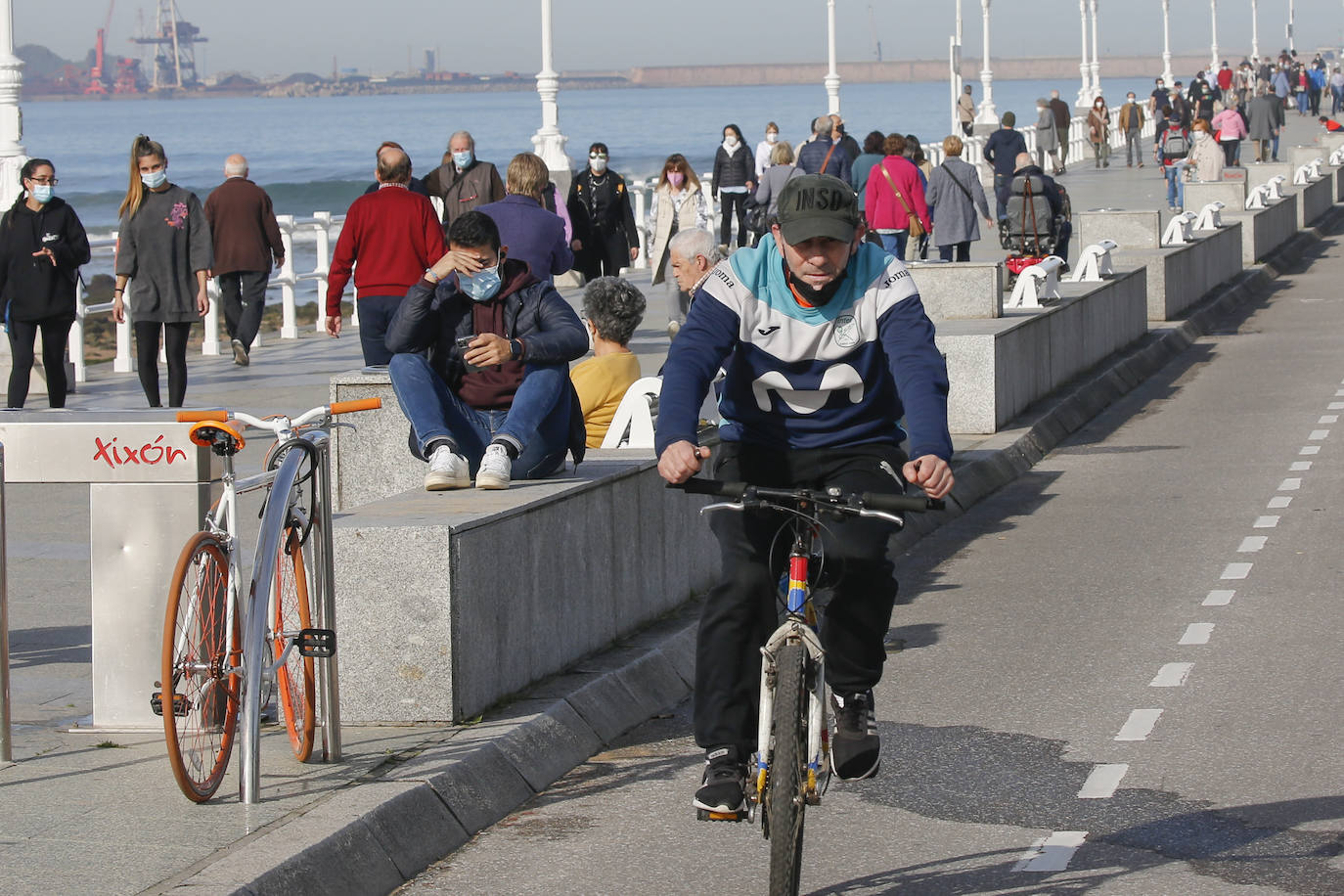 Las agradables temperaturas de este jueves y el sol permitieron que muchos gijoneses optasen por disfrutar de El Muro y de la playa en pleno mes de enero.