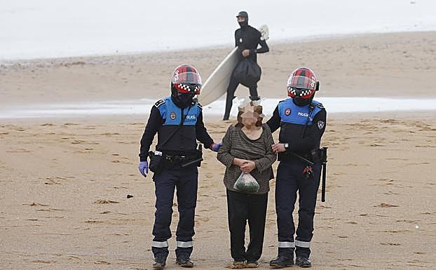 La mujer, acompañada por los agentes de la Policía Local de Gijón