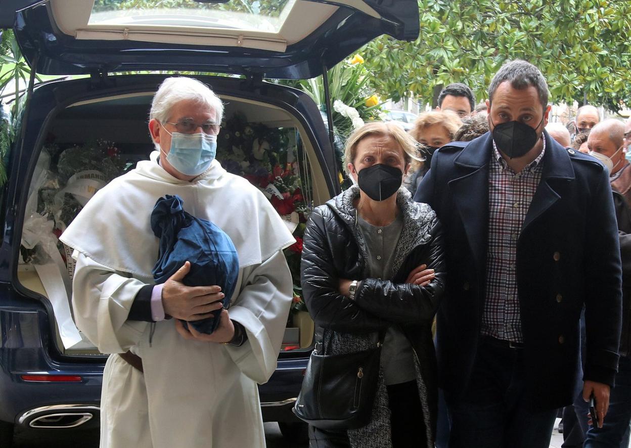 El párroco José Antonio Rodríguez, con la viuda y el hijo de Virgilio García. 