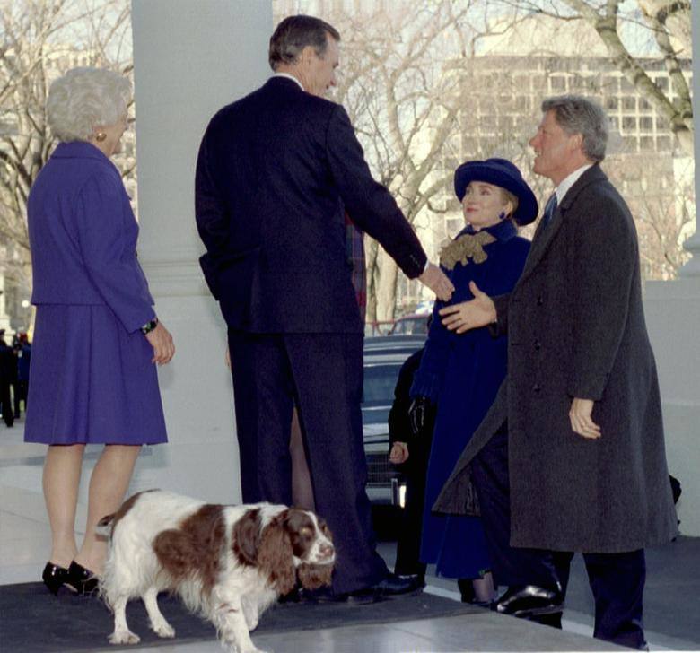 El presidente electo Bill Clinton le da la mano al presidente George Bush, tras llegar a la Casa Blanca el 20 de enero de 1993. En primer plano está el perro de los Bush, Millie