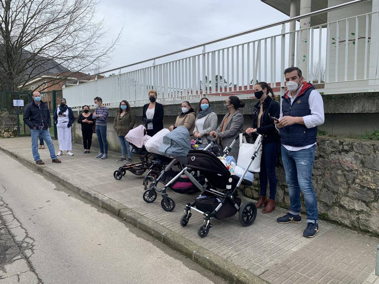 Las familias afectadas, con sus bebés, ayer ante la escuela de 0 a 3 de Posada de Llanes. 