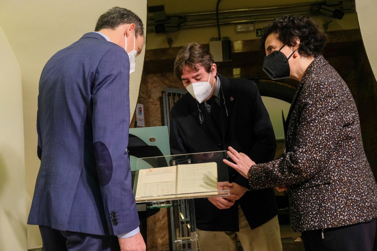 Pedro Duque, Luis García Montero y Berta Piñán observan el cuaderno de Severo Ochoa. 