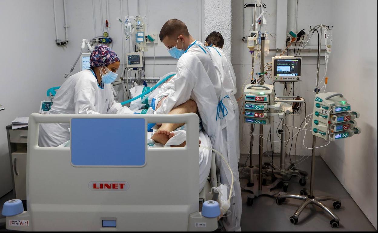 Sanitarios mueven a un paciente de covid-19 en la UCI del Hospital de Sabadell.