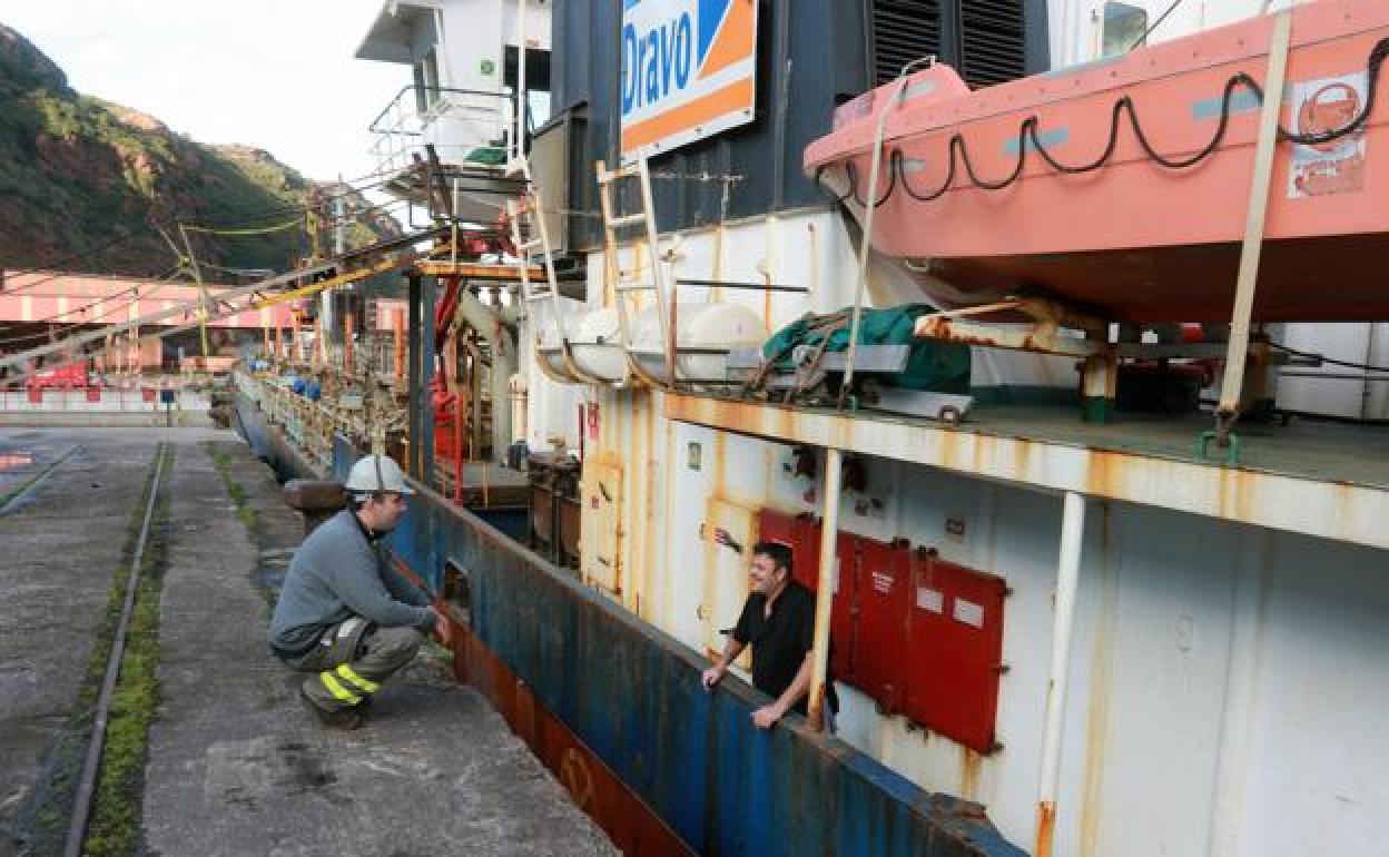 Un trabajador de DDR Vessels habla con uno de los tripulantes que trajo a El Musel la draga 'Dravo Costa Dorada'. Jesús Manuel Pardo
