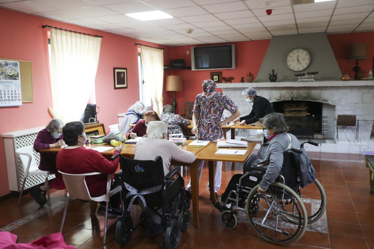 Un grupo de usuarios de una residencia participan en una actividad en el salón. 