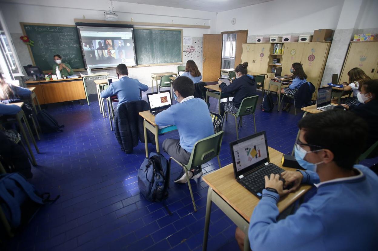 Clase en un aula del colegio Santa María del Naranco, en Oviedo, con las ventanas y puerta abierta. 